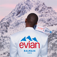 The back of a woman's jacket displaying the evian and balmain logos.